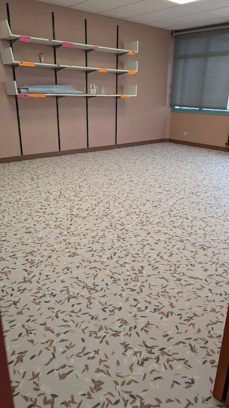 Salle vide avec étagères murales modulaires en métal noir et supports colorés orange et rose