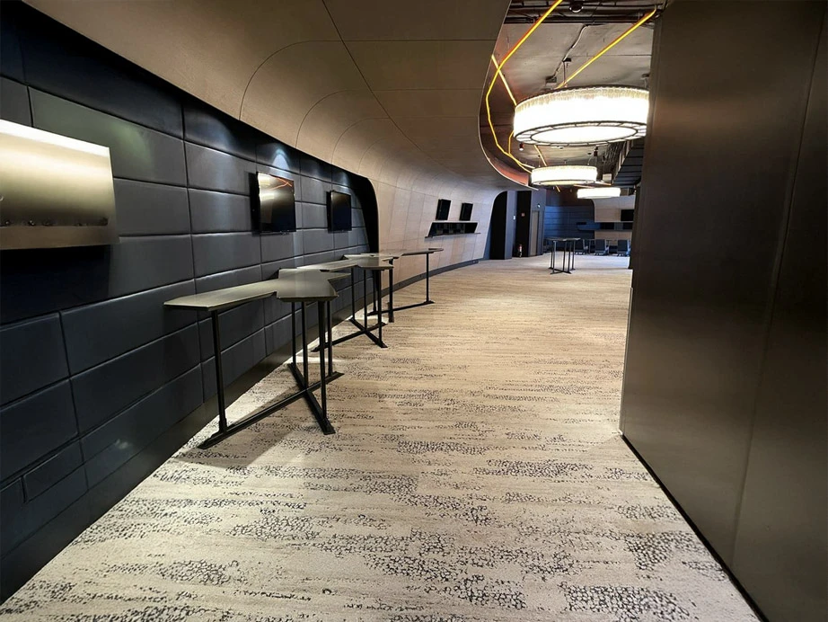 Espace de travail collaboratif moderne avec tables hautes et tabourets dans un couloir d'entreprise