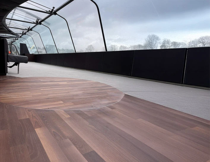 Femme souriante pr&eacute;sentant &eacute;chantillon de parquet dans showroom d'am&eacute;nagement int&eacute;rieur