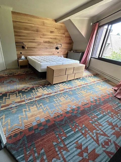 Intérieur moderne avec grande baie vitrée donnant sur rue, rangée de cylindres noirs le long des fenêtres, espace ouvert lumineux avec éclairage naturel