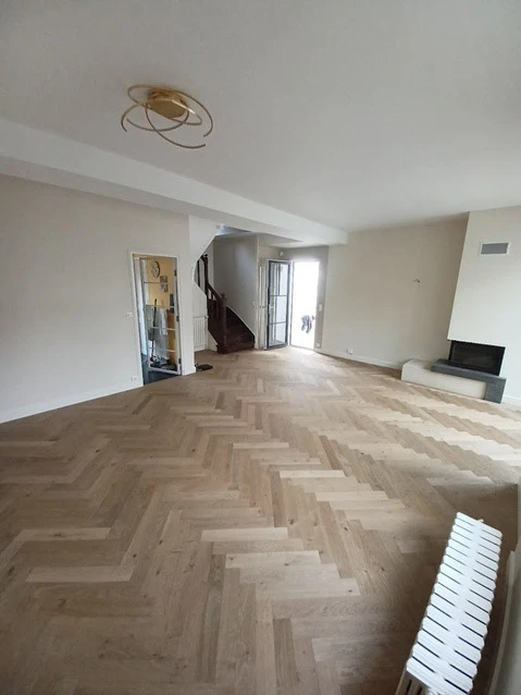 Intérieur moderne avec grande baie vitrée donnant sur rue, rangée de cylindres noirs le long des fenêtres, espace ouvert lumineux avec éclairage naturel