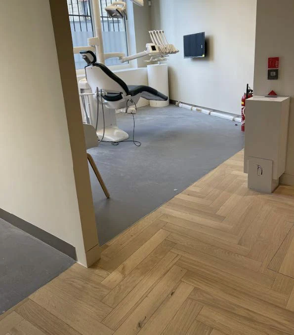 Intérieur moderne avec grande baie vitrée donnant sur rue, rangée de cylindres noirs le long des fenêtres, espace ouvert lumineux avec éclairage naturel