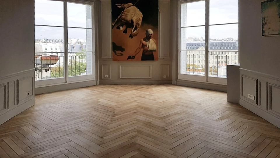 Salon moderne avec canapé bleu clair, meuble TV en bois clair et blanc, écran plat monté, mur texturé anthracite éclairé par spots encastrés