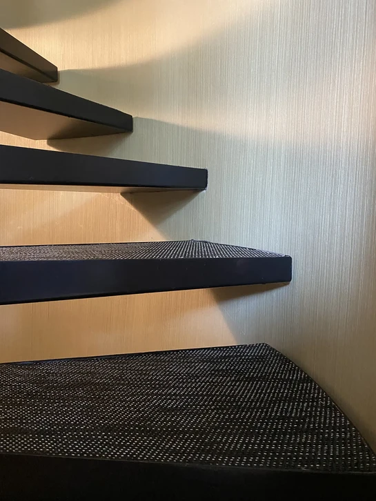 Père et fils assis ensemble sur un canapé dans un salon moderne, consultant une tablette numérique